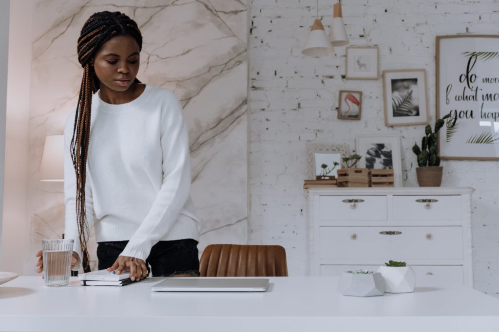 woman in white long sleeve shirt standing beside white table