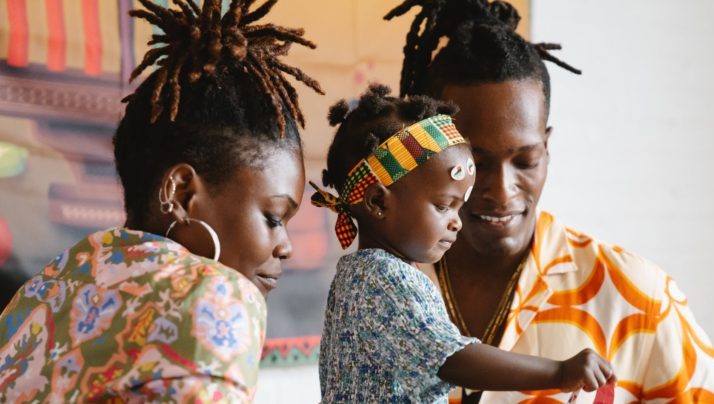 couple making an artwork with their daughter